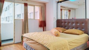 A bedroom with a bed, a window, a mirror, and a ceiling light. - The Royale Sentra Tower Kuning (Jakarta)