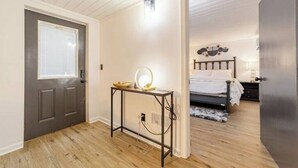 A bedroom with a bed, bedside table, and a mirror.