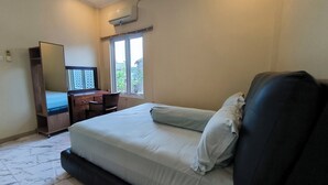 Ein Schlafzimmer mit Bett, Kommode, Stuhl und Fenster.