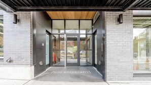 A modern building entrance with a glass door, a wooden ceiling, and a metal frame. - Pleasant Condotel with WiFi in Vibrant First Hill (Seattle)