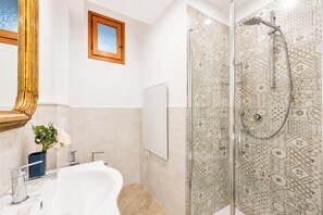 A bathroom with a glass-enclosed shower, a white bathtub, and a large mirror. - Central Flat With Private Parking in Genova (Genoa)