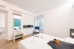 A modern hotel room with a bed, a chair, a desk, and a large window. - Central Flat With Private Parking in Genova (Genoa)