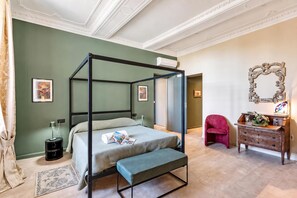 A four-poster bed with a bench, a dresser, a mirror, and artwork on the walls. - Precious House Genova Porto Antico (Genoa)