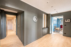 A hallway with a dark wall, a light-colored floor, and a door leading to another room. - Precious House Genova Porto Antico (Genoa)