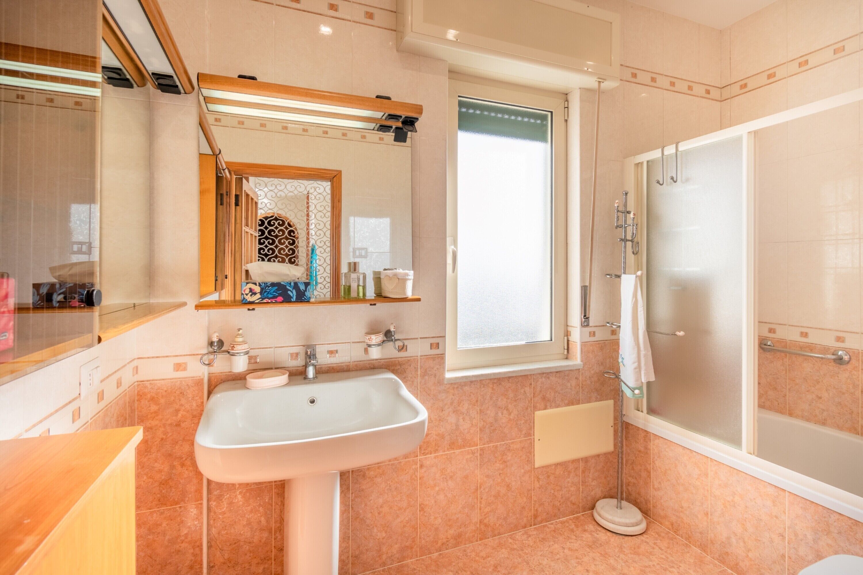 A modern bathroom with a sink, mirror, and shower.