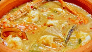 A clay pot filled with a seafood stew. - Munril Guest (Jaffna)