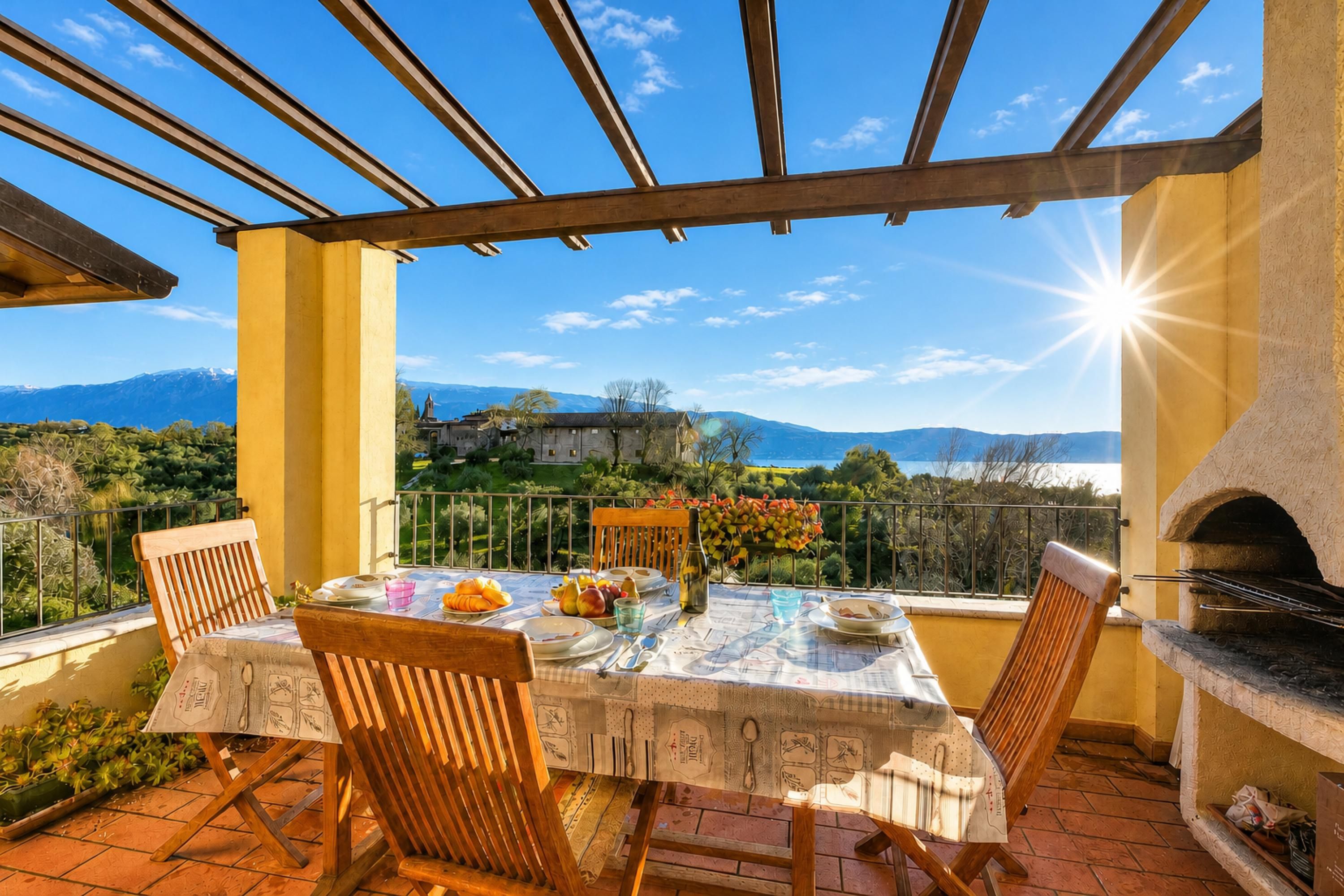 Une terrasse avec une table dressée pour le dîner, offrant une vue sur un paysage montagneux.