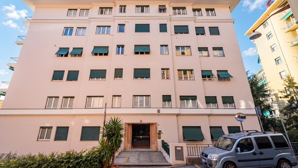 A multi-story building with a flat facade, multiple windows, and a central entrance. - House Rondinella Genova City Center (Genoa)