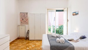 A bedroom with a bed, a radiator, a wardrobe, a window with a view, and a painting on the wall. - House Rondinella Genova City Center (Genoa)