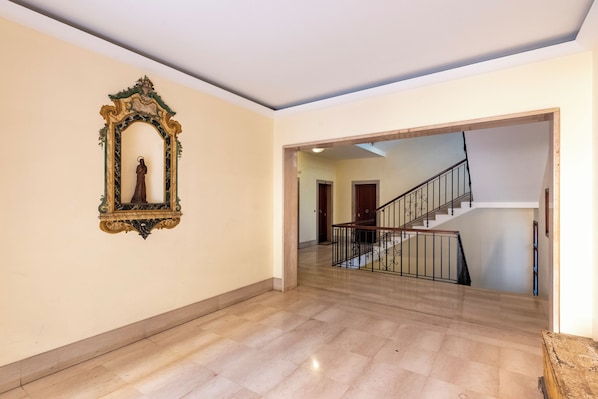 A spacious hallway with a marble floor leading to a staircase with a metal railing. - House Rondinella Genova City Center (Genoa)