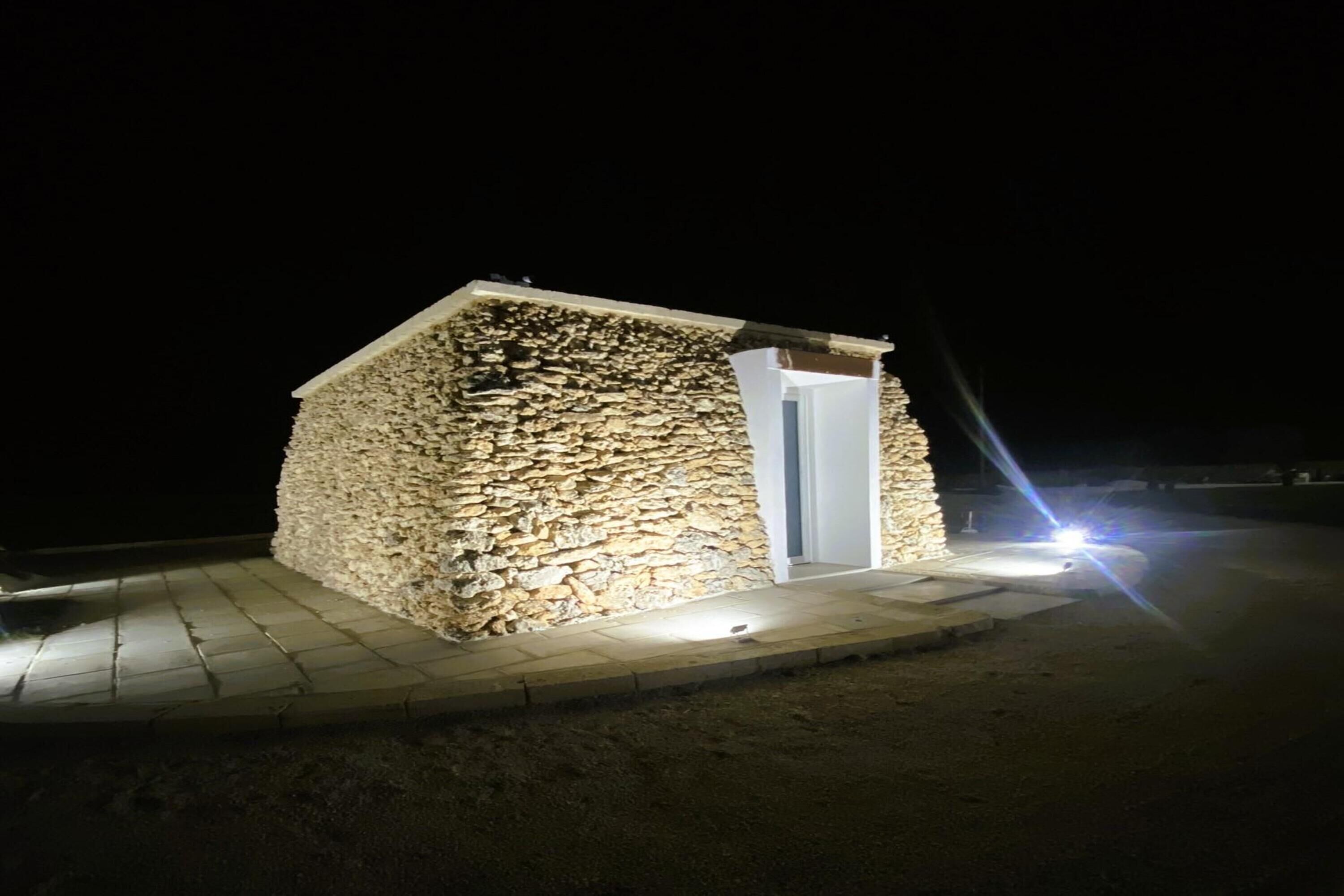 A stone building with a door and a small porch area.