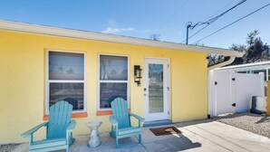 A yellow building with two windows, a white door, and a small porch with two Adirondack chairs. - 1 Block to Beach: Gulf Coast Escape w/ Patio! (Fort Myers Beach)