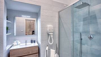 Ein modernes Badezimmer mit Duschkabine aus Glas, einem Holzwaschtisch und einem Spiegel über dem Waschbecken.