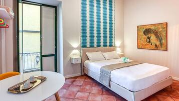 Ein Hotelzimmer mit Bett, Nachttischlampen, einem Tisch mit Tablett, einem Fenster mit Blick und einer Wand mit Streifenmuster und Kunstwerken.