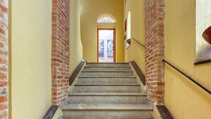 A staircase with brick walls and a door at the top.