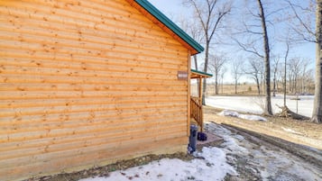 Situated in a serene natural setting, this cabin offers a peaceful retreat with a wooden door and window.
