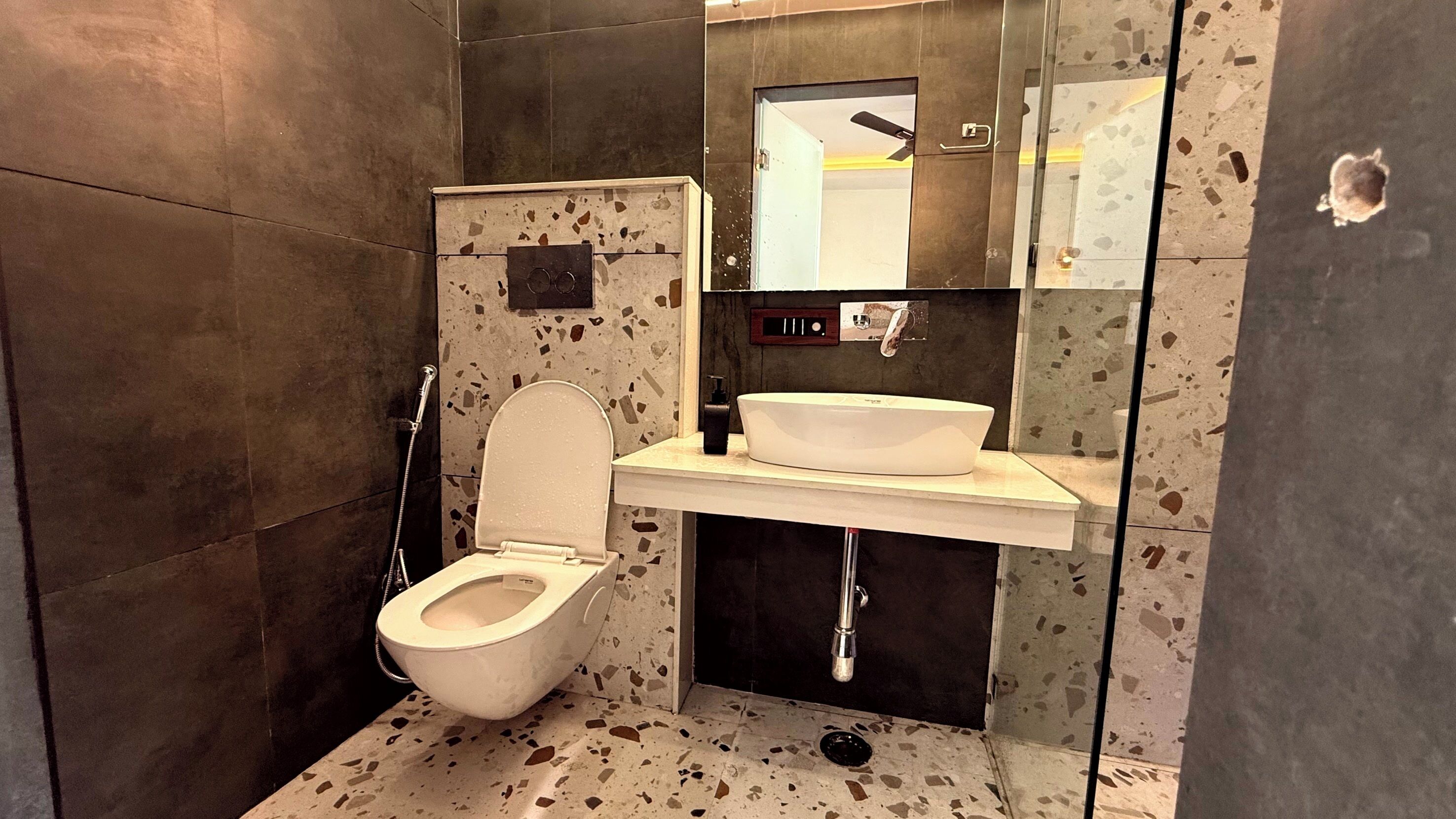 A modern bathroom with a toilet, sink, and shower.