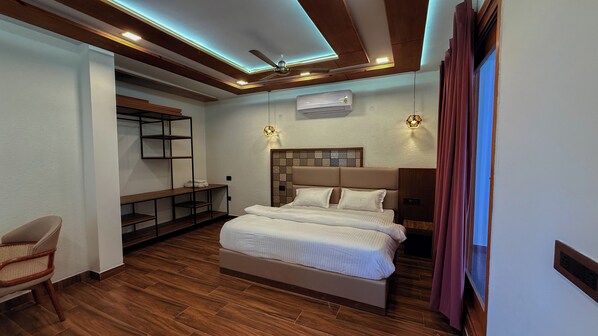 Quarto de hotel com cama, escrivaninha e cadeira.
