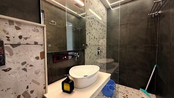A modern bathroom with a large sink, a mirror, and a shower area. - Yes Hotel By The Ganges (Rishikesh)
