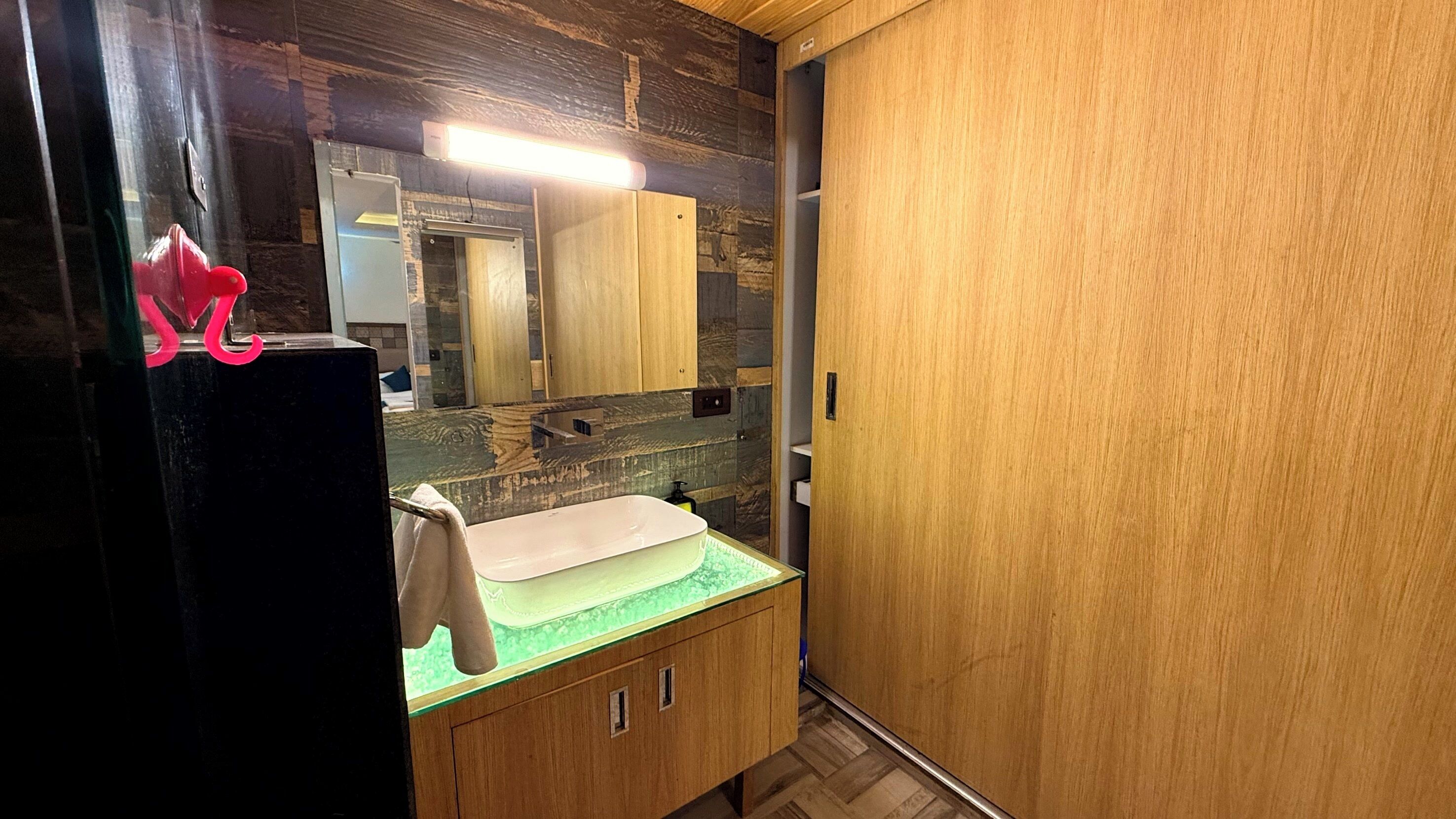 A bathroom with a wooden vanity, a mirror, and a sink.