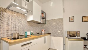 A modern kitchen with white cabinets, a wooden countertop, a built-in oven, and a microwave. - Ravanas 314 Bari Near Station (Bari)