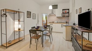 A compact kitchen with a dining table, chairs, a TV, and a microwave. - Ravanas 314 Bari Near Station (Bari)