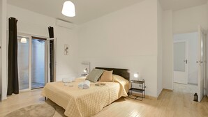 A bedroom with a bed, bedside tables, a lamp, a radiator, and a sliding glass door. - Ravanas 314 Bari Near Station (Bari)