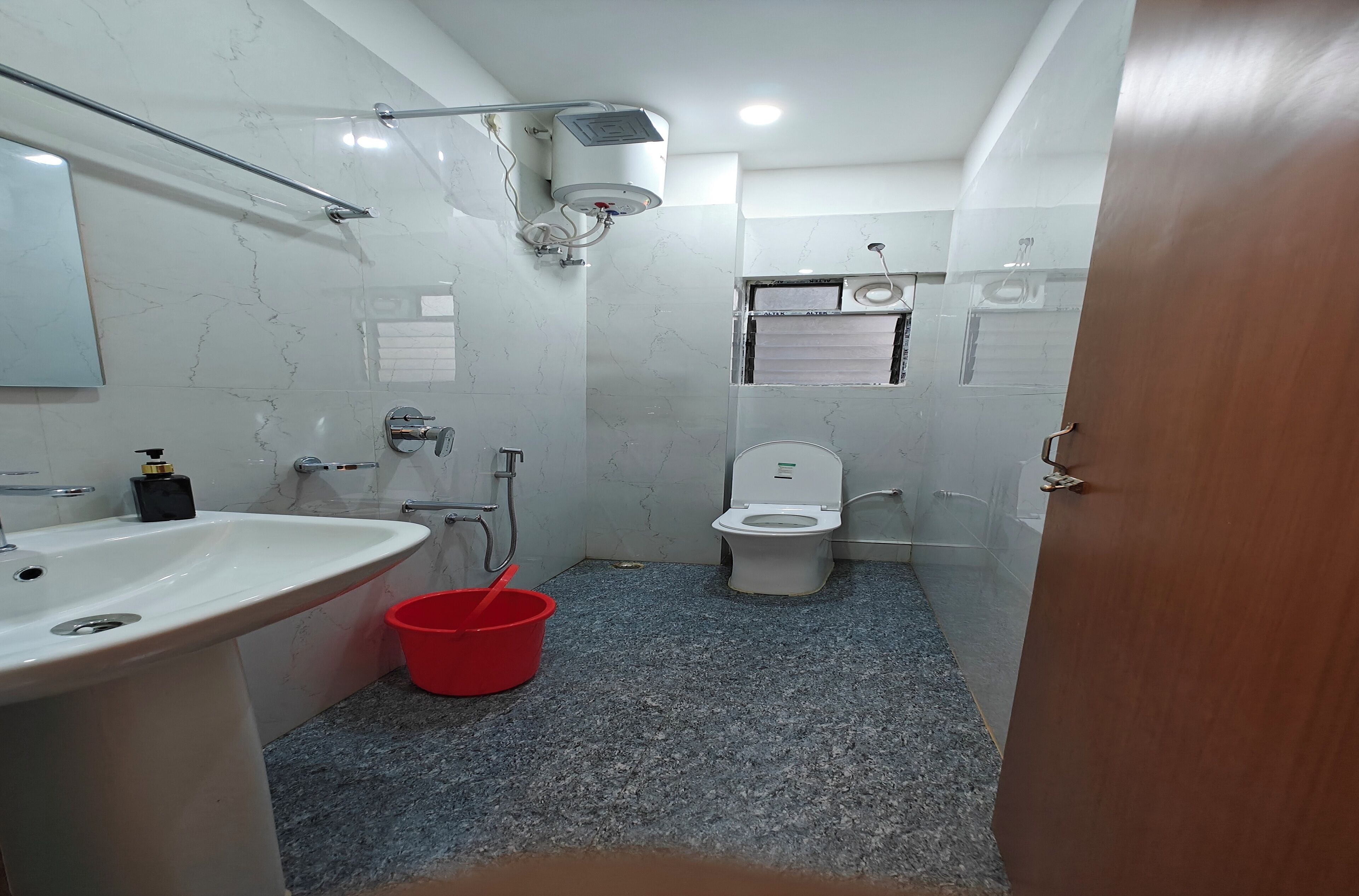A compact bathroom with a sink, toilet, and shower.