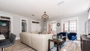 A modern living room with a sectional sofa, a coffee table, and two armchairs. - 20 Hypolita Street (St. Augustine)