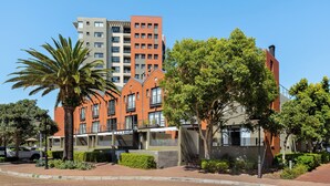 A modern building with a brick facade, large windows, and a flat roof. - Modern 3-Bed Home , Canal Views & Parking (Cape Town)