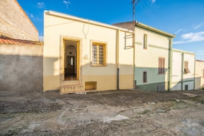 A building with a yellow facade, a door, and a window.