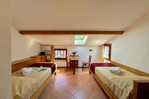 A room with two beds, a small table with chairs, a skylight, and a window. - Borgo di Porlezza (Porlezza)