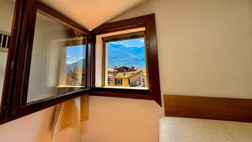 Una habitación con ventana que da a un paisaje montañoso.