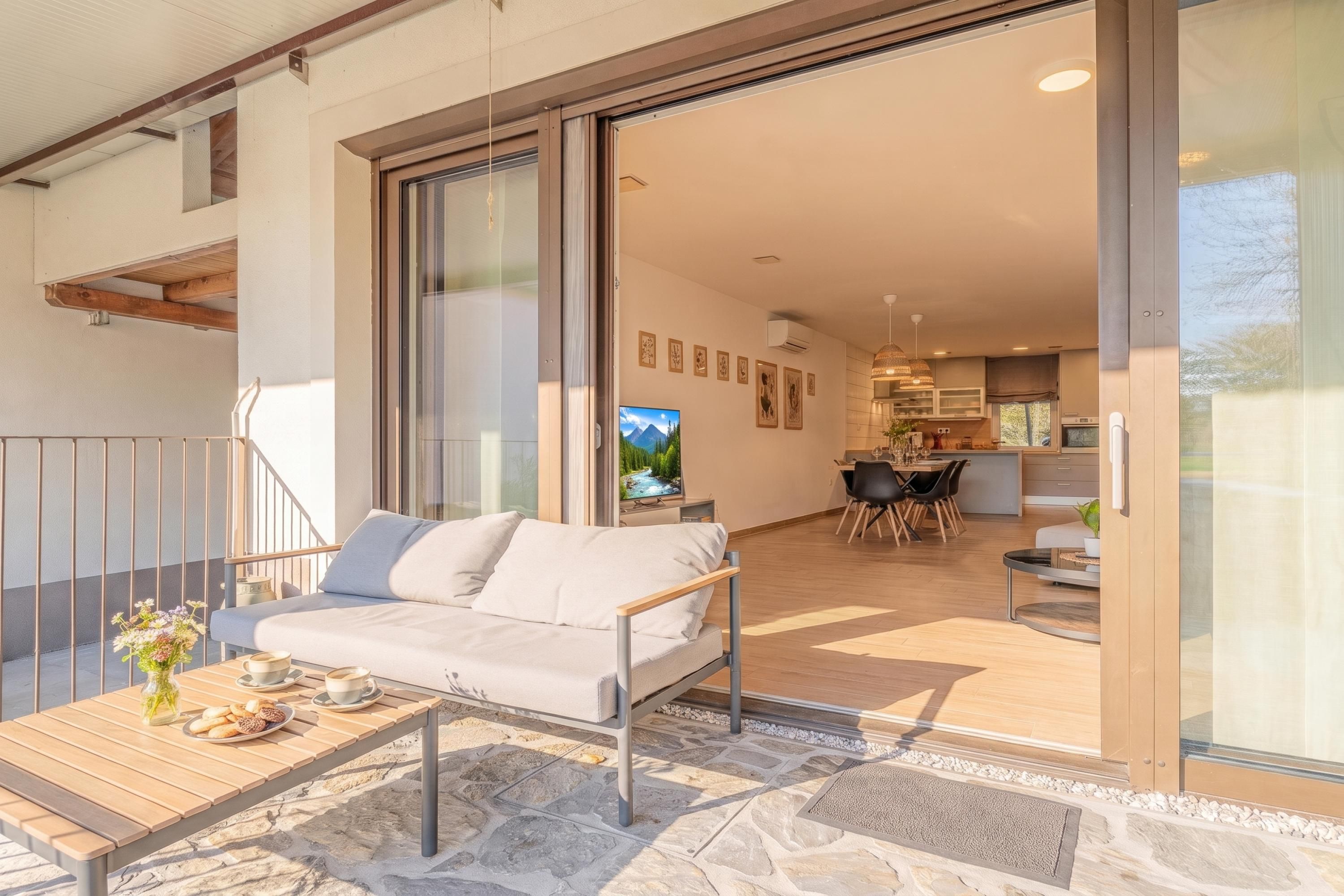 A modern living space with a sofa, dining table, and kitchen area.