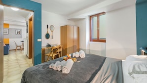 Een hotelkamer met een bed, een bureau, een stoel en een kledingkast.
