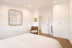 A bedroom with a bed, a chair, a wardrobe, and a mirror. - The Country Apartment - Gorgeous new accommodation on prestige property (Richmond Lowlands)