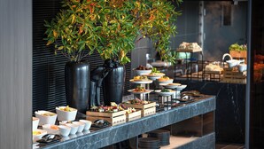 Mesa de buffet con diversos platos y una planta decorativa.