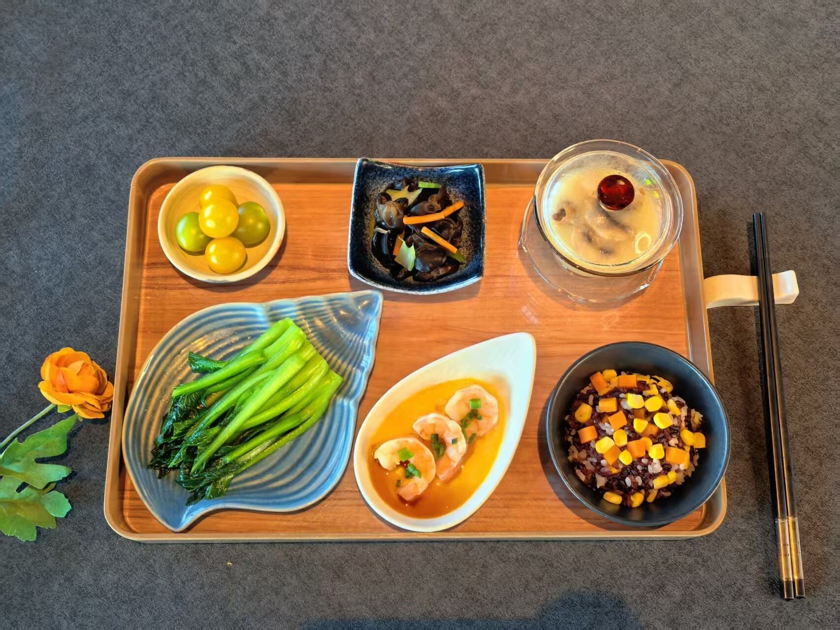 A tray with various dishes including vegetables, shrimp, and a dessert.