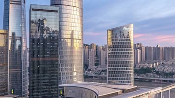 Un paysage urbain moderne avec de hauts immeubles, un pont incurvé et une rivière.