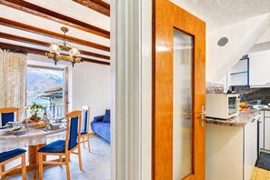 A modern kitchen with a microwave, a sink, and a window overlooking a mountainous landscape. - Casa Patrizia Caviano Gambarogno With Lake & Mountain Views (Gambarogno)