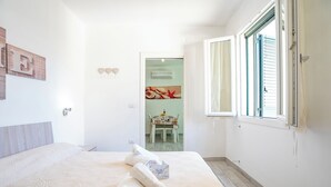 Ein Hotelzimmer mit Bett, Fenster und Blick auf einen Speiseraum.