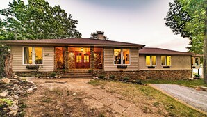 A two-story house with a stone facade, a front porch, and a driveway leading to the entrance. - Unparalleled Views, Sauna, Hot Tub, Fire Pit, Game Room | Panorama by AvantStay (Sevierville)