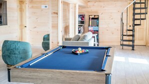 A pool table with balls in a room with wooden walls and a staircase. - Unparalleled Views, Sauna, Hot Tub, Fire Pit, Game Room | Panorama by AvantStay (Sevierville)