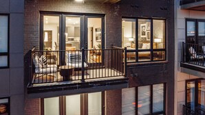 A multi-story building with a balcony featuring a seating area with a table and chairs. - Pool + Gym Access | Walk to Centennial Park | West End | Outlaw's Den (Nashville)