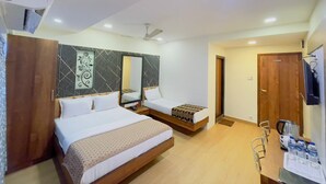 A hotel room with two beds, a desk with a chair, a mirror, and a TV. - hotel abraj inn  (Mumbai)
