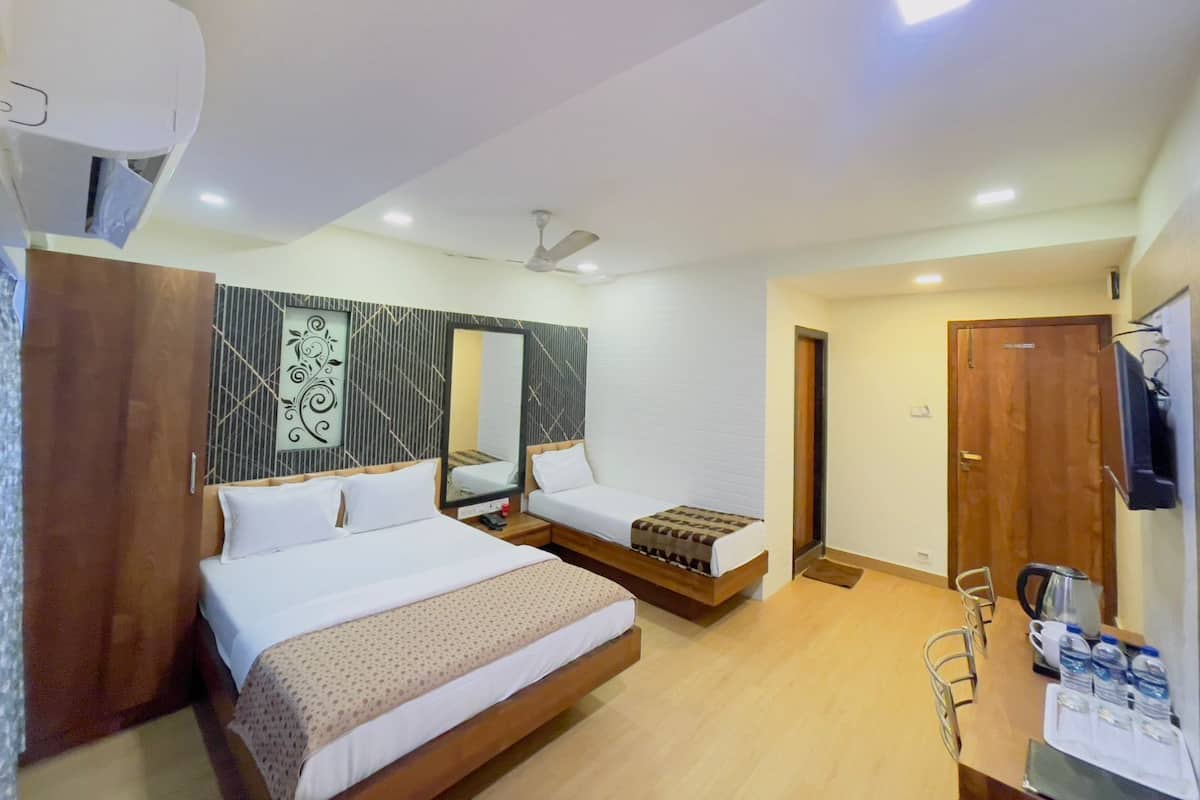 A hotel room with two beds, a desk with a chair, a mirror, and a TV.