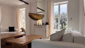 Ein modernes Wohnzimmer mit einer Couch, einem Holztisch und einer Pendelleuchte.