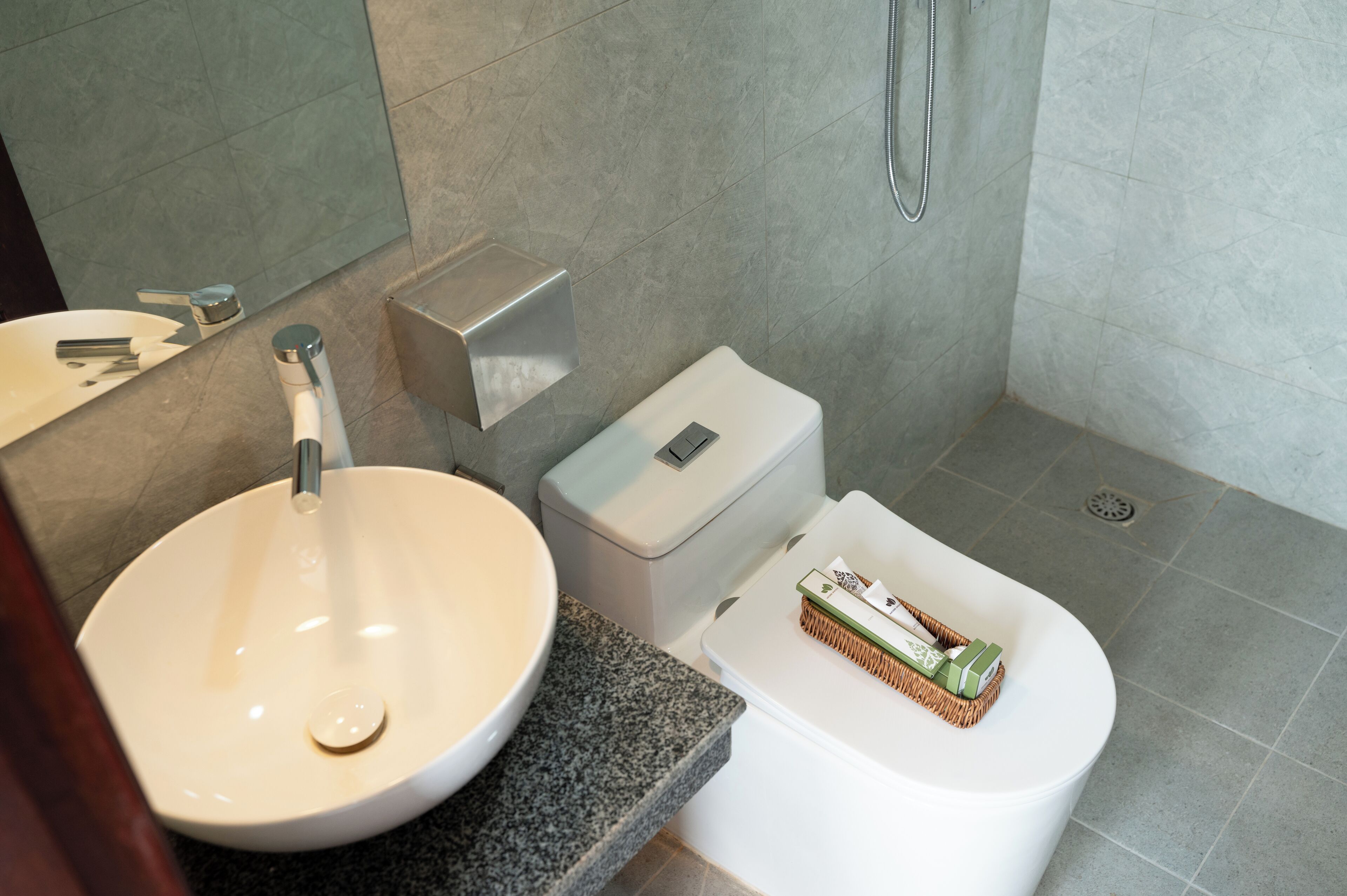 A modern bathroom with a white sink, toilet, and shower.