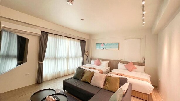 A modern hotel room with a sofa, two beds, a small table, and a large window with curtains. - Sweet Home (Sanxing)