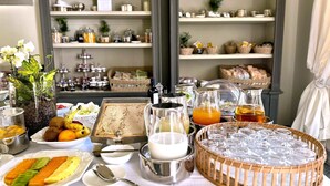 Un bufé de desayuno con diversos alimentos, bebidas y una planta decorativa.
